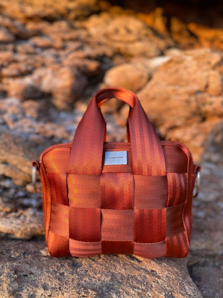 Rust coloured HILLA bag outside on some rocks